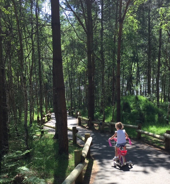 little girls cycling through Center Parcs Woburn Forest - top tips, take a bike with you