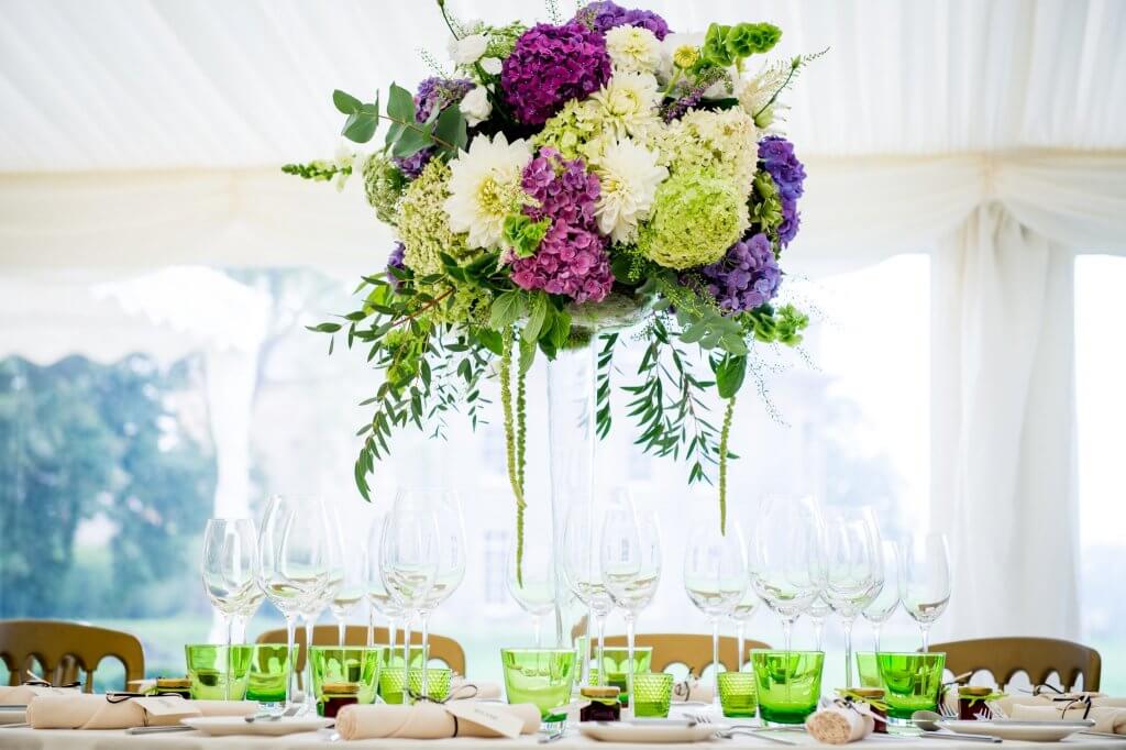 White and purple flowers in high table setting for wedding