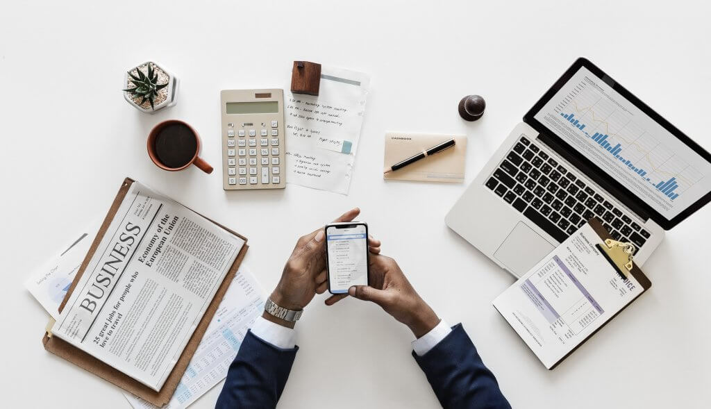 is investing for everyone? Man has lots of devices to help with investing - paper, phone and computer